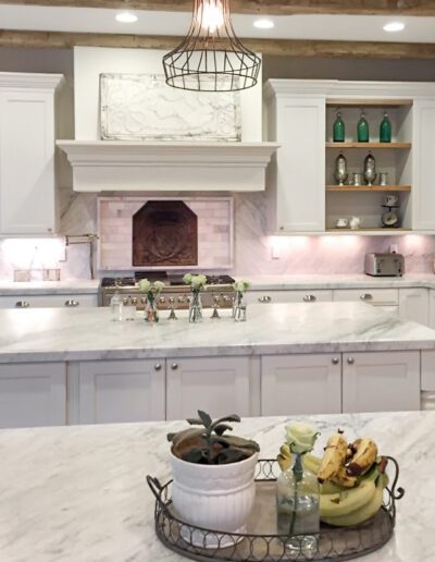 Elegant white kitchen interior with marble countertops and a central island.
