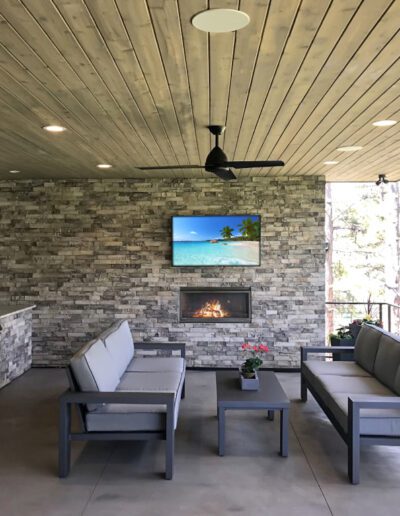 A well-appointed outdoor living space with a kitchen, fireplace, and seating area.